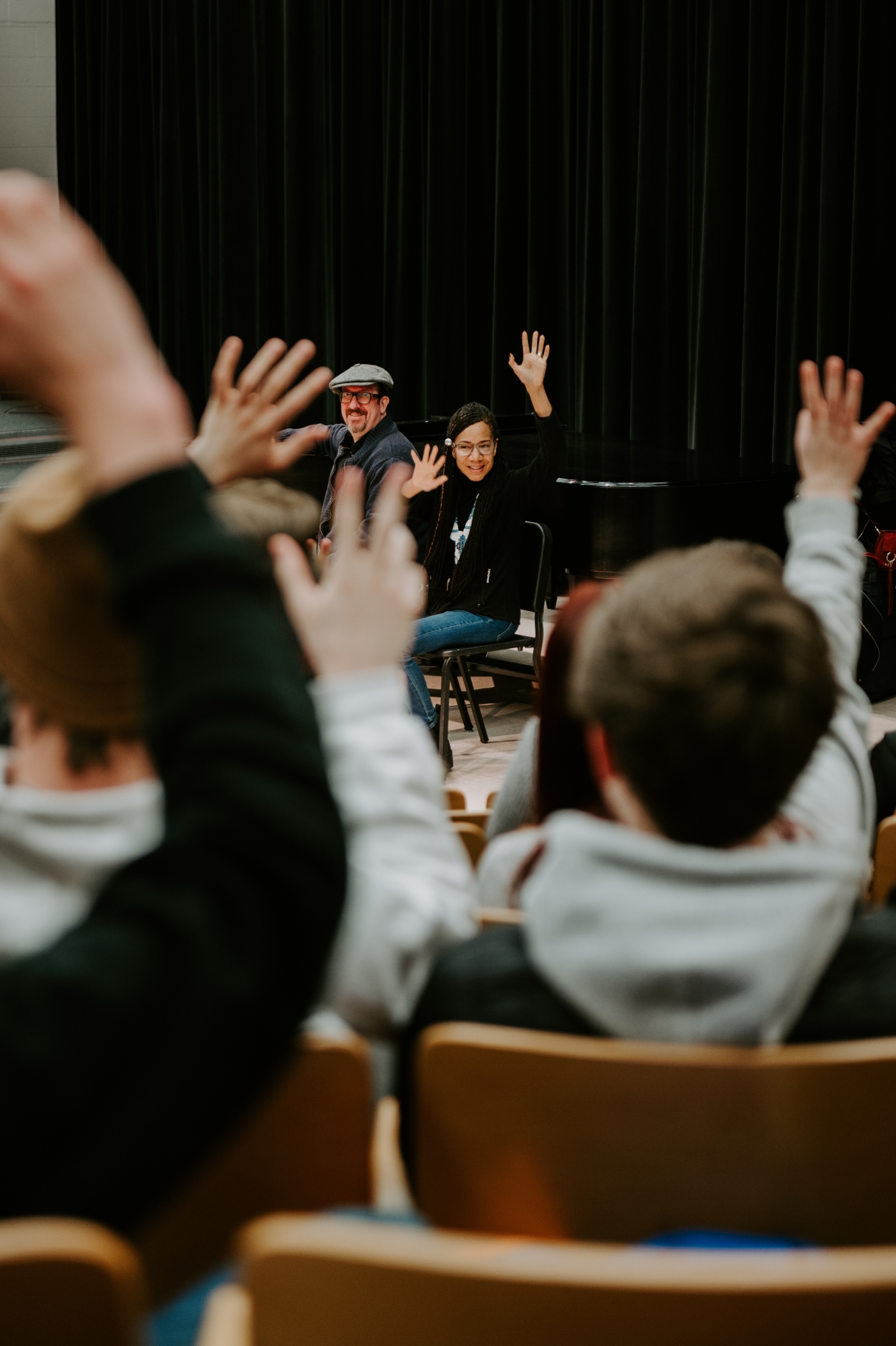 Students raising their hand during a convocation class