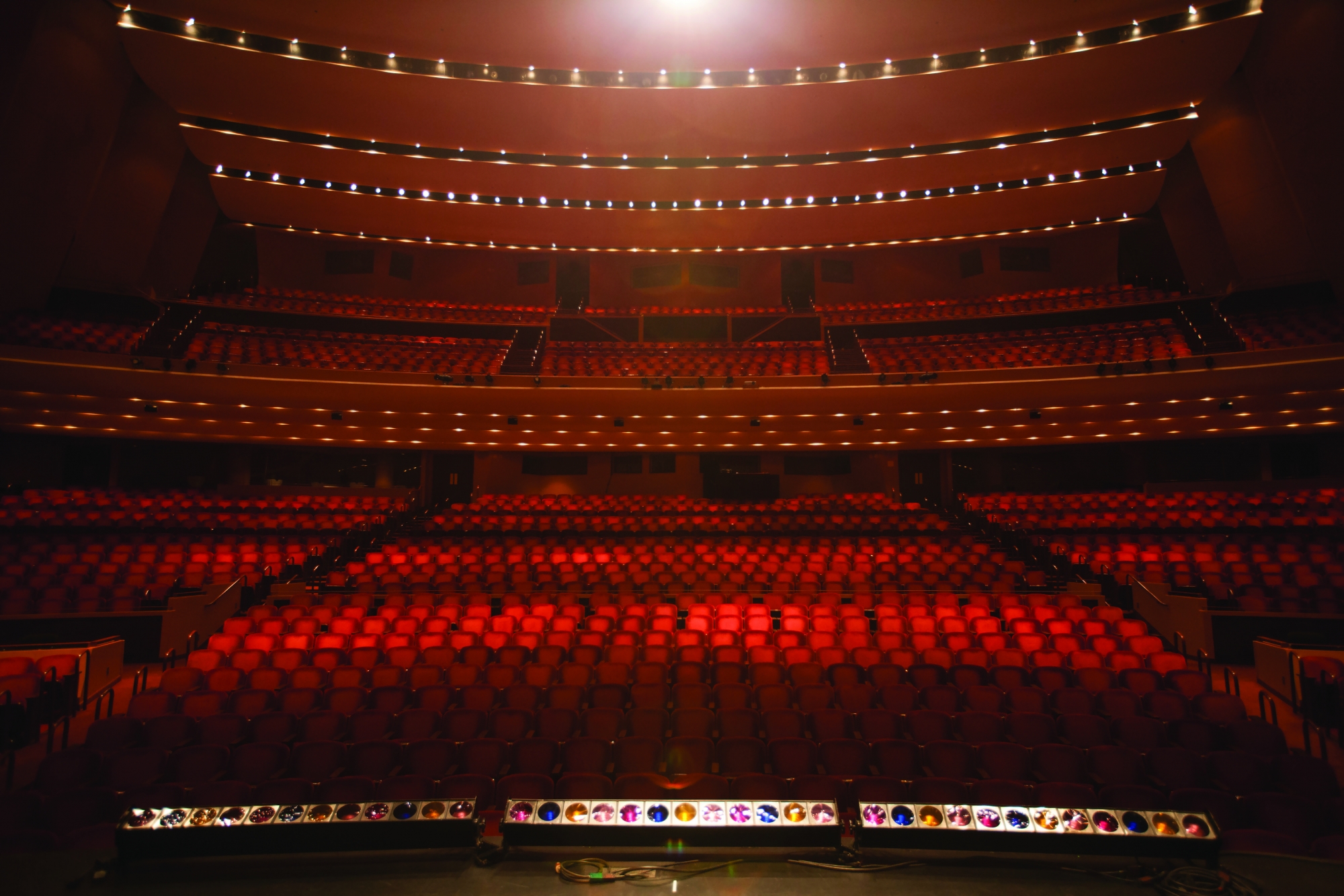 Image of the Lied Center auditorium taken from the stage looking out into an empty hall full of red, plush seats.