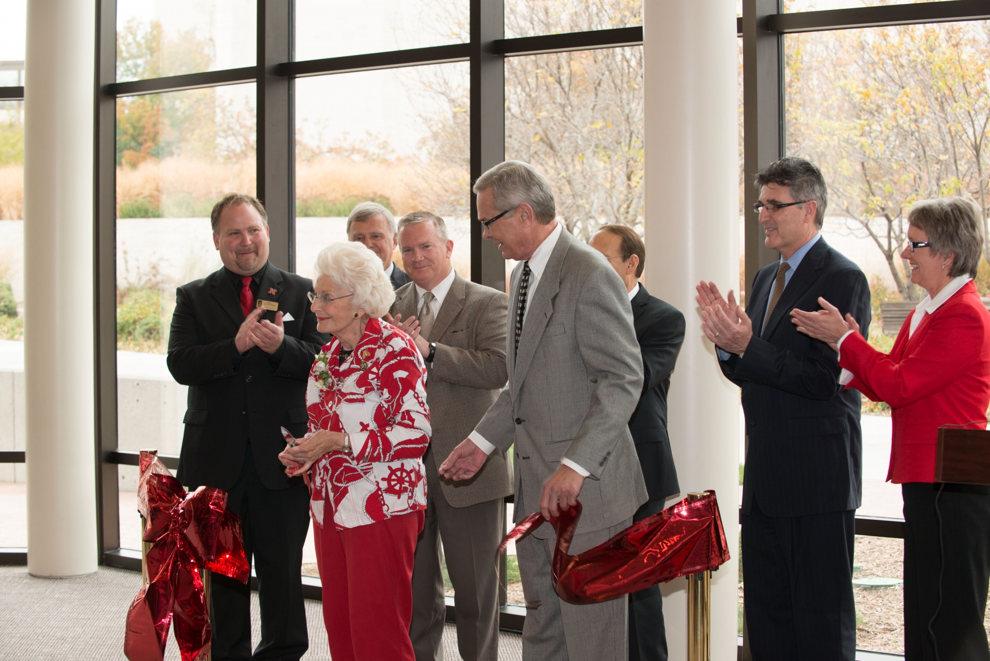 Image of the ribbon cutting for the Lied Commons building showing Christina Hixson, the Mayor of Lincoln, and other dignitaries applauding after the ribbon is cut.