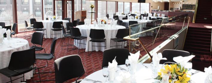 Image of the Orchestra Lobby highlighting the beautiful view and a banquet setup featuring black chairs around white tables.