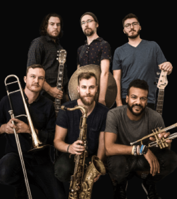 Six men look into the camera. From left to right they hold: A guitar, a cymbal, a bass guitar, a trombone, a tenor saxophone, and a trumpet. 