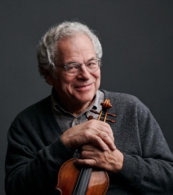 Image of Itzhak Perlman holding a violin with both of his hands, smiling at the camera
