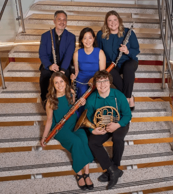5 instrumentalists pose on a staircase