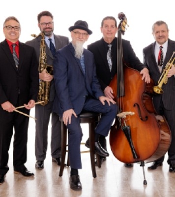 Five men holding jazz instruments looking at the camera in front of a white background