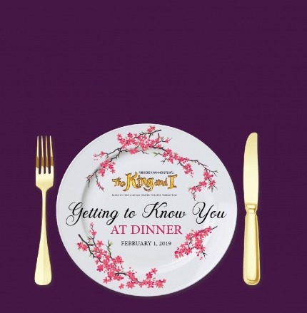 White plate with a purple background and golden fork and knife next to the plate. Cherry blossoms decorate the plate and the words "Getting to know you at dinner" are written on the plate.