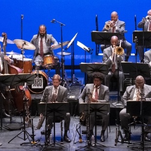 members of a jazz band on stage performing