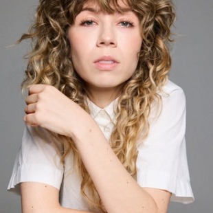 headshot of a woman with wavy hair in white tee shirt