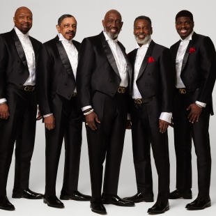 five men in black tuxedos looking suave