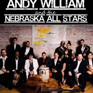 a group on classy-dressed musicians posed together against a brick wall