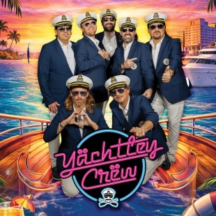 a seven-piece yacht rock band poses in captains outfits against a vibrant ocean sunset
