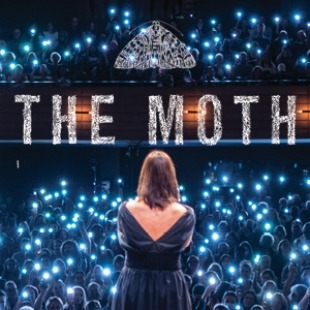 A woman on a stage looking to a crowd with cell phone lights. A logo of a moth with "THE MOTH" is written at the top