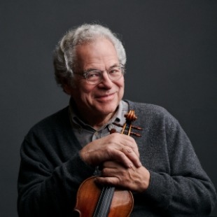 Image of Itzhak Perlman holding a violin with both of his hands, smiling at the camera