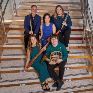 5 instrumentalists pose on a staircase