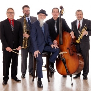 Five men holding jazz instruments looking at the camera