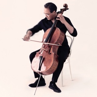 Photo by Jason Bell: Image of a man playing a cello in front of a beige background