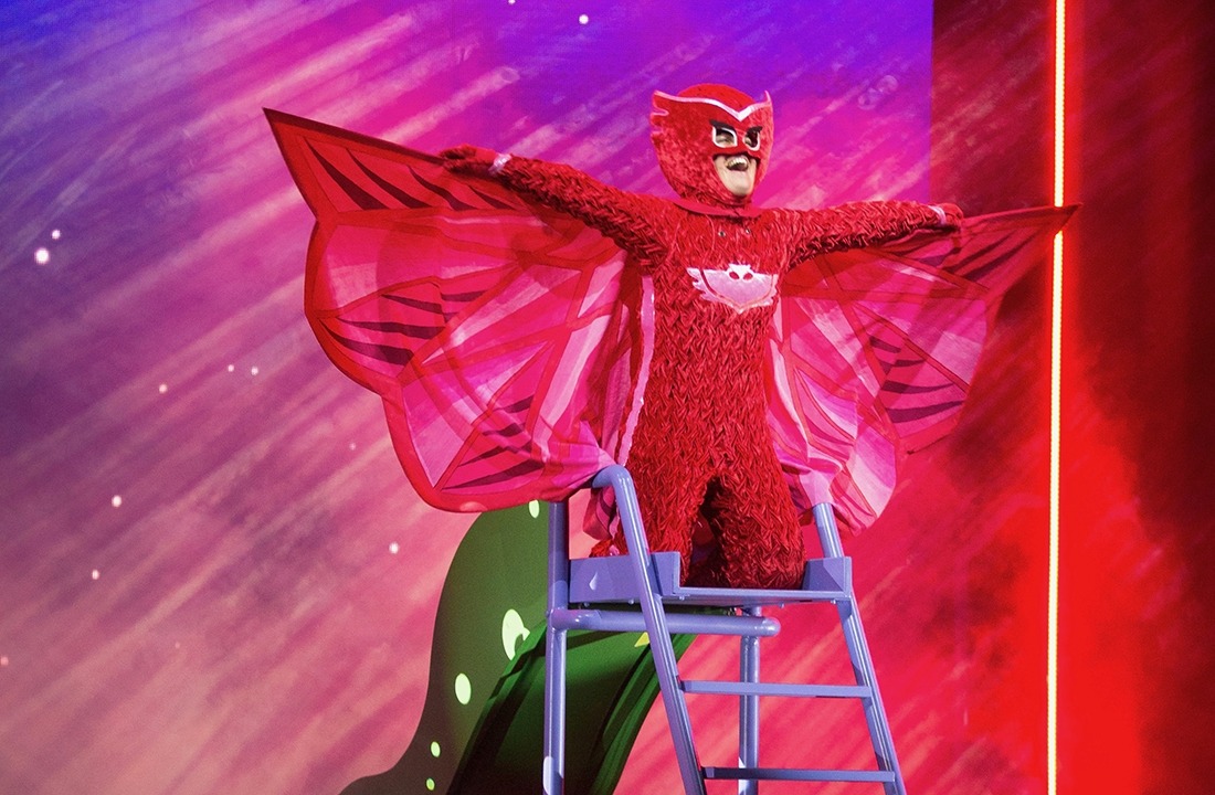 Image of PJ Mask's Owlette in a red costume, kneeling on a ladder with wings spread wide.