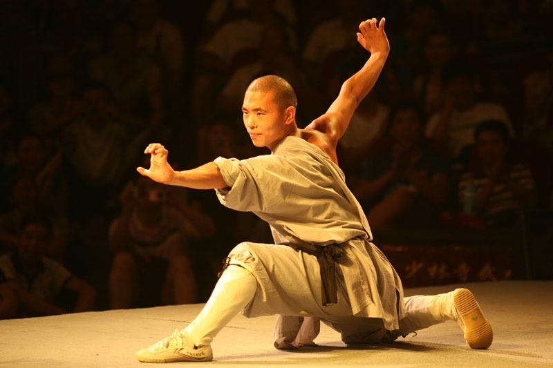 A man performing martial arts in ancient Chinese costume