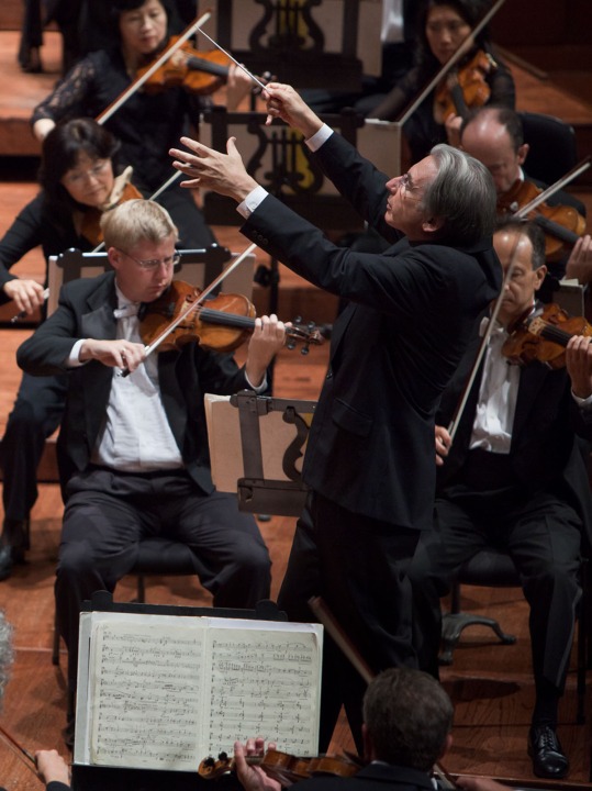 Close up and side angle of Michael Tilson Thomas conducting the symphony