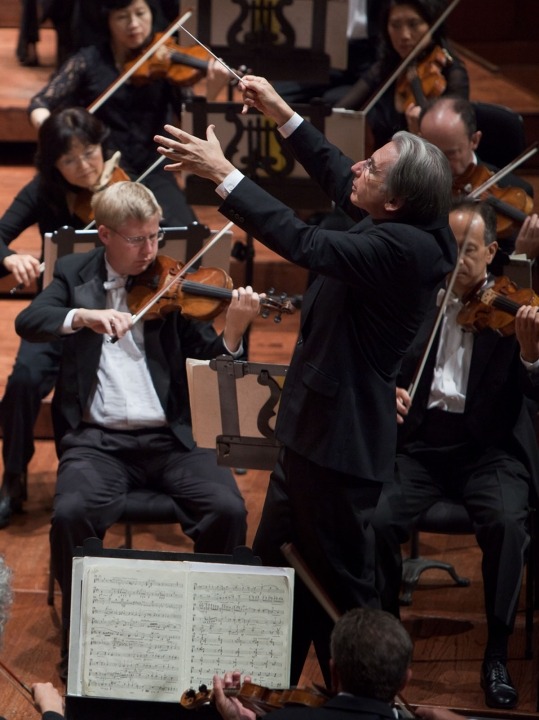 Close up and side angle of Michael Tilson Thomas conducting the symphony