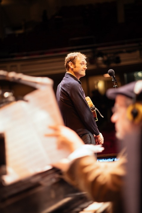 Chris Thile and a pianist turning his music page perform as part of Live from Here.
