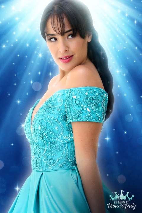 Courtney Reed in a blued dress in front of a blue background