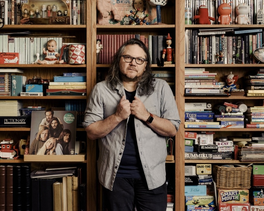 Wilco's Jeff Tweedy Jeff Tweedy standing in front of a bookcase.