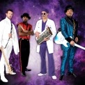 Image of the backing band for Purple Rain dressed in their various costumes standing in front of a purple background.