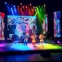 Image of the performers in RAIN on stage in colorful outfits in tribute to the Beatles of the Sgt. Pepper era.