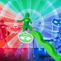 Image of PJ Masks Owlette, Gekko and Catboy in red, green, and blue, posing on playground aparatus.