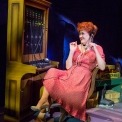 Woman in a red dress with a headset on sitting at a switchboard