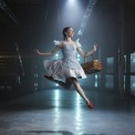 Woman in a blue dress and red shoes jumping in a room with a blue light behind her