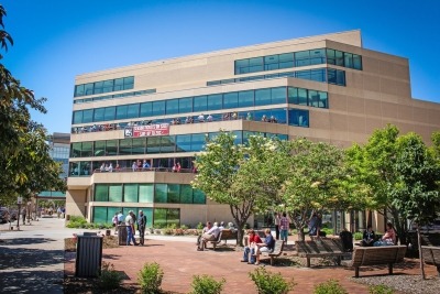 Photo of the Lied Center outside with people sitting in the Lied Plaza