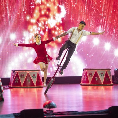 photo of two acrobats performing under red and white lights