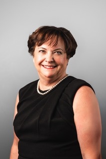 headshot of Deb Nelson a woman with short dark brown hair wearing a black sleeveless top