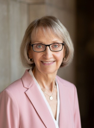 headshot of Linda Dickeson wearing a pink blazer and glasses