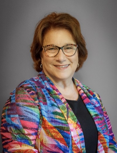 headshot of current FOL President Nancy Krumland wearing glasses and a colorful jacket