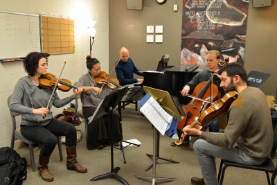 Image of Paul Barnes practicing with the Chiara String quartet in the foreground