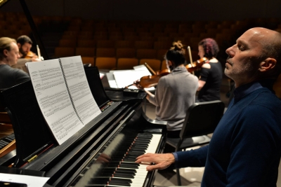 Image of Paul Barnes at a piano with the quartet in the background