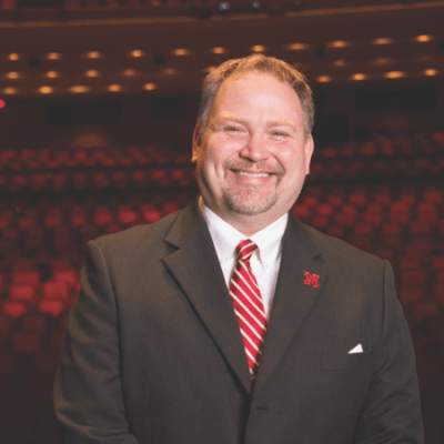 Image of Bill Stephan sitting in the iconic red seats of the Lied Center auditorium