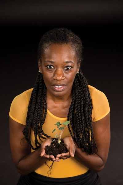 Image of a character from Seedfolks holding a small plant seedling
