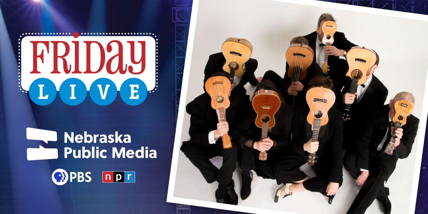 8 men in suits sit with their legs crossed, holding ukuleles in front of their faces, in front of a blue background that reads "Friday Live Nebraska Public Media" in red and white text.