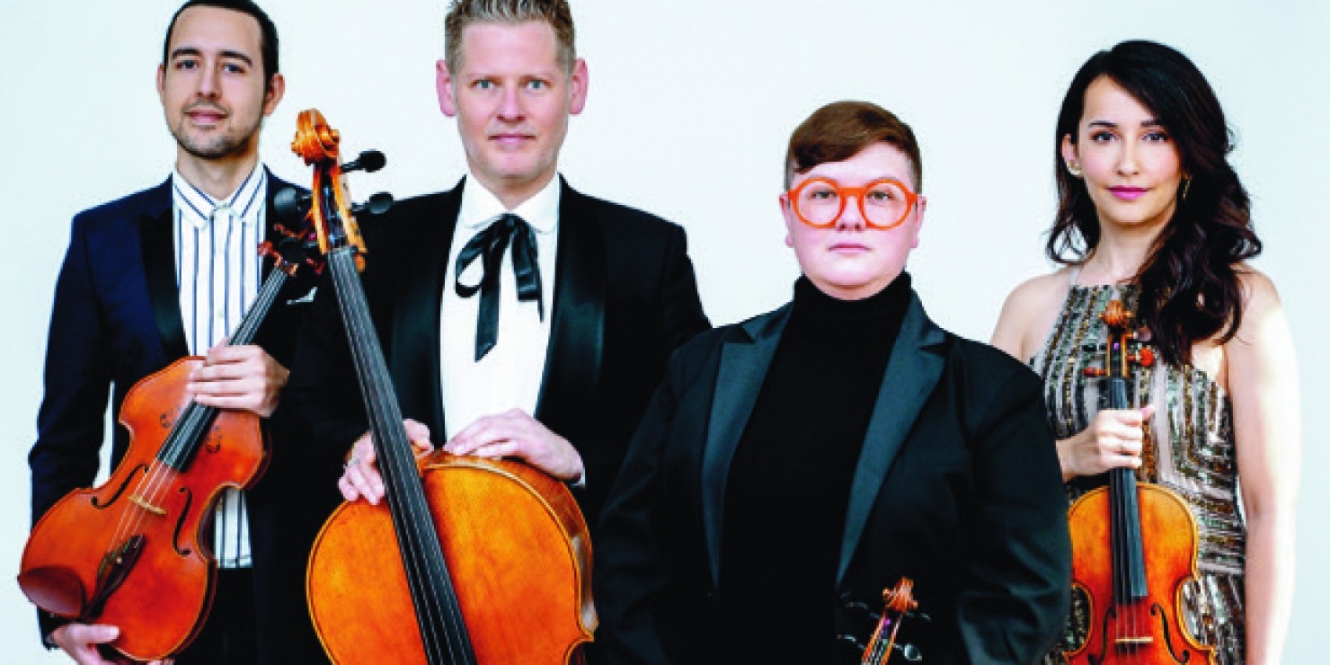 quartet of string musicians pose together in fancy attire