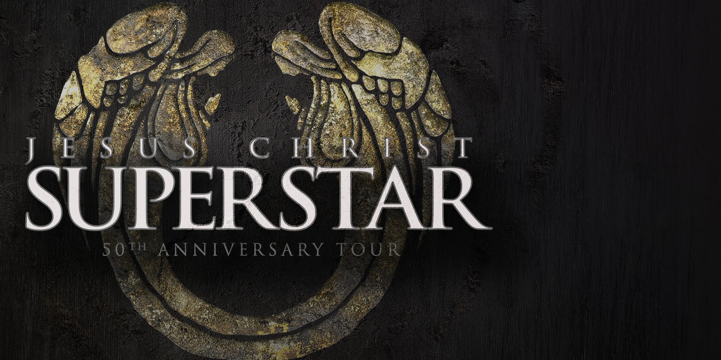 Image with Jesus Christ Superstar written in the middle. Background has a pair of angel like wings that look like stone
