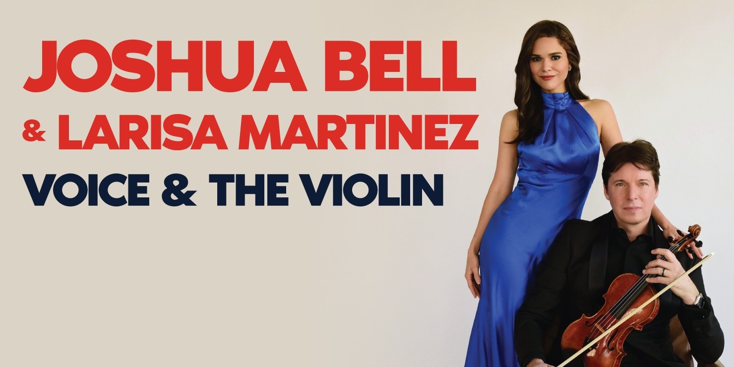 Man with short brown hair sitting in a chair wearing a black suit and black shirt holding a violin in his lap and holding a viol