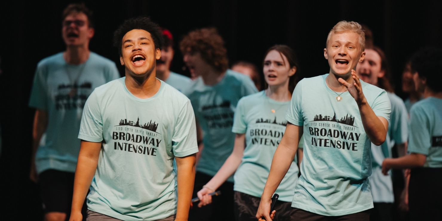 Young artists singing in blue shirts.