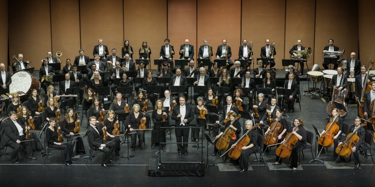 a large orchestra on stage dressed in mostly black