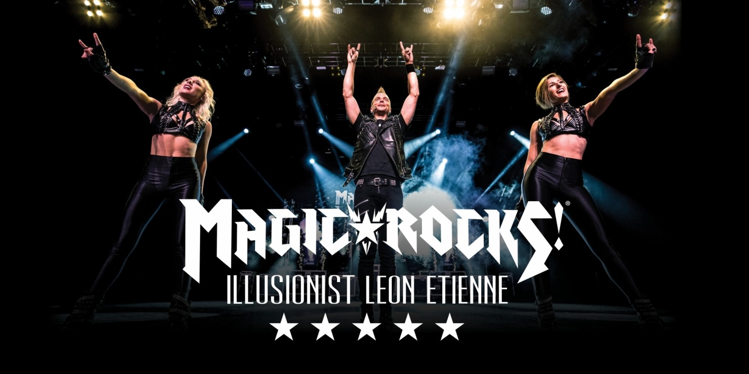 a rock and roll styled man and two women pose on stage with hands in the air
