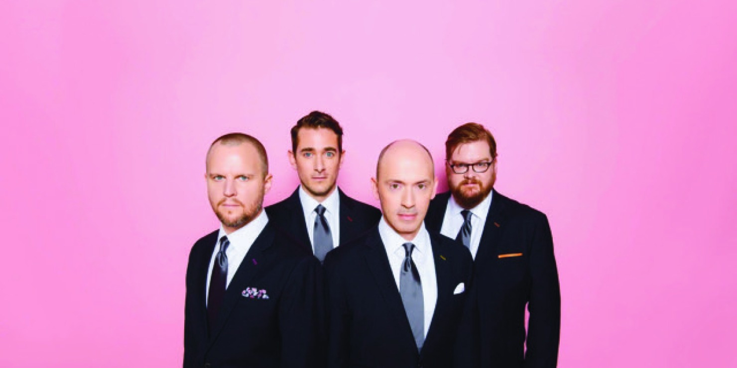 a quartet on men in fancy attire pose in front of a purple-pink background