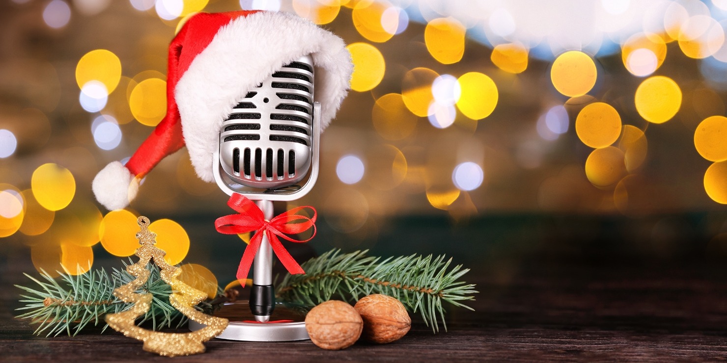 Microphone with a santa hat in front of a gold and brown background