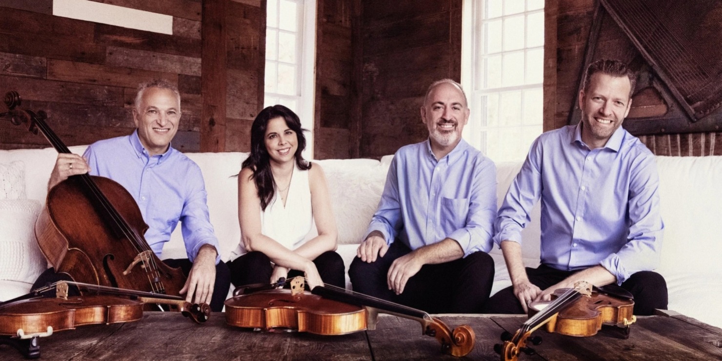 a musical quartet pose together for a promotional picture in nice clothing